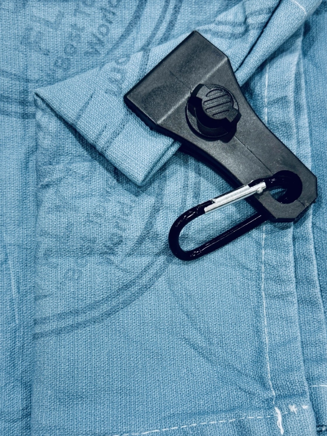 Dub Towel clipped to a disc golf bag in the field